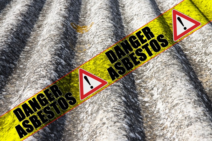 The message “danger asbestos” written on a yellow stripe